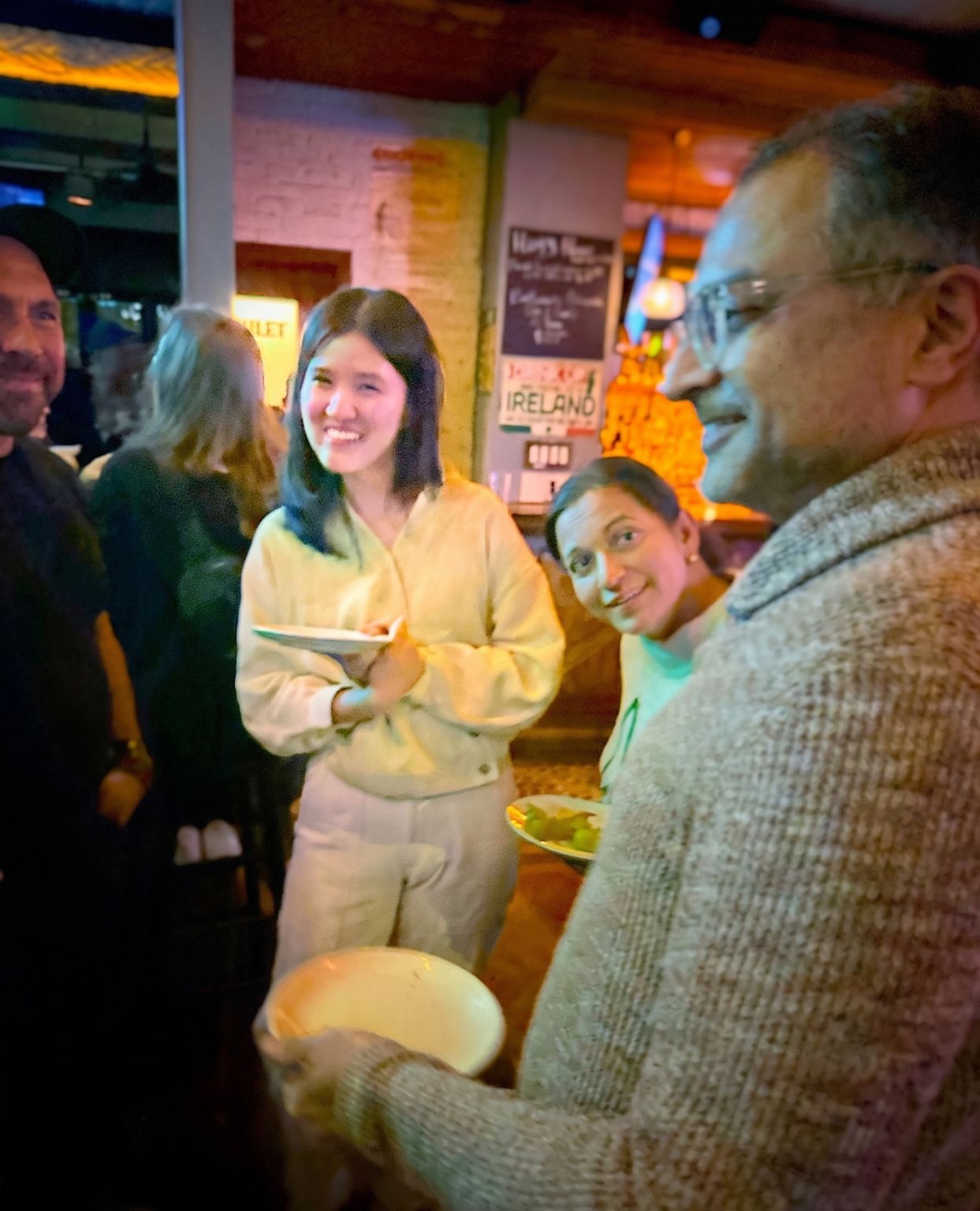 Attendees with plates, smiling as they mingle