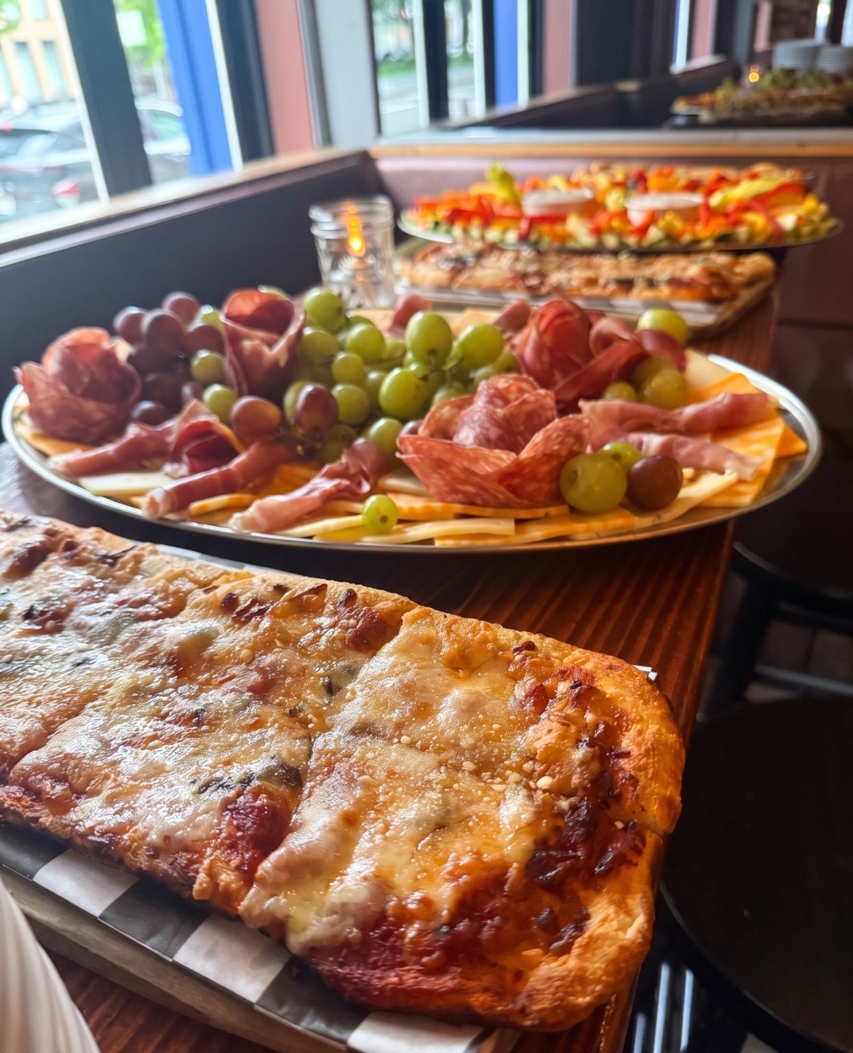 Flatbread pizza, a charcuterie platter and crudités laid out along a bar